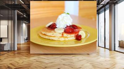 Buttermilk pancake filled with sliced banana and strawberries Wall mural