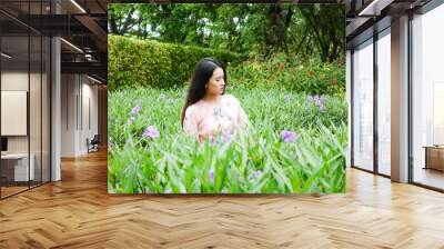 Portrait of beautiful young asian woman relaxing in garden Wall mural