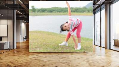 Happy girl exercise at health park Wall mural