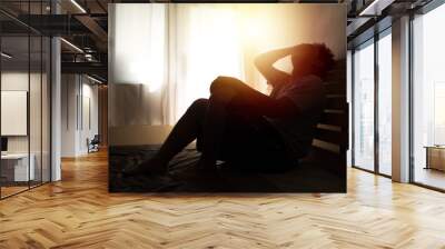 desperate man in silhouette sitting on the bed with hands on head , headache after weak up Wall mural