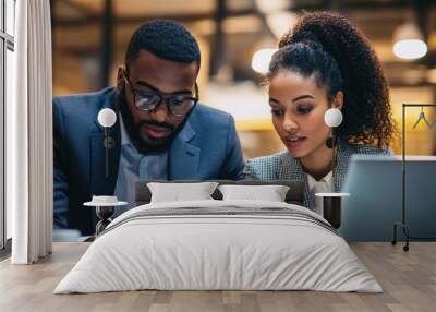 Two young business colleagues working together on a computer. Wall mural