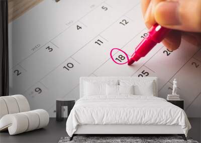 Female Hand with pen mark on calendar date Wall mural