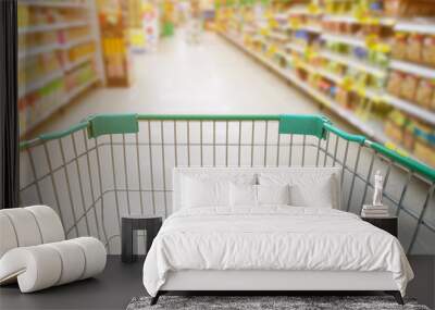 supermarket aisle with empty green shopping cart Wall mural