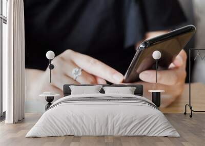 Woman with diamond ring on hand using smartphone in cafe restaurant Wall mural