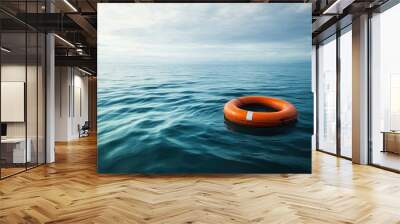 A life buoy floating alone in the ocean, representing a lifeline in the middle of a vast sea. Wall mural