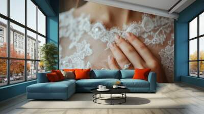 A close-up of the neckline of a wedding dress, with a girl's hand on it and a wedding ring on her ring finger Wall mural