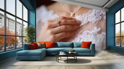 A close-up of the neckline of a wedding dress, with a girl's hand on it and a wedding ring on her ring finger Wall mural