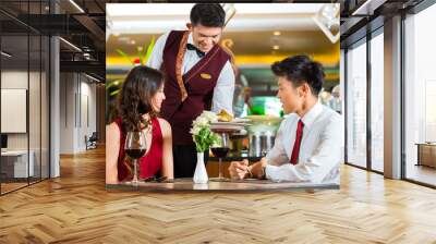 chinese waiter serving dinner in elegant restaurant or hotel Wall mural