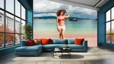 Fashionable young woman with a perfect body smiling while posing outdoors during summer vacation at Pink Beach, pink, in Komodo Island, Indonesia  Wall mural