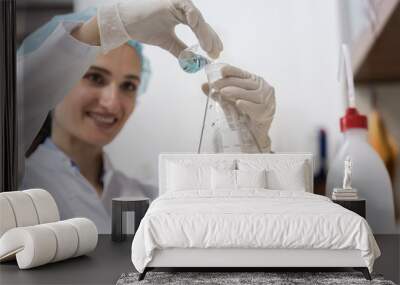 low-angle view of the hands of a successful chemist smiling while mixing two liquid chemical substan Wall mural