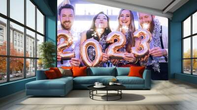 Men and women celebrating the new year 2023 with sparklers and wine Wall mural