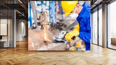 Metal worker in factory grinding metal of pipeline Wall mural