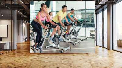 Rear low-angle view of two fit women with an active lifestyle burning calories during indoor cycling class in a modern fitness club Wall mural