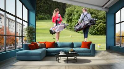 Rear view of couple carrying golf bag Wall mural