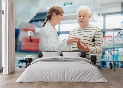 Senior man with pharmacist in pharmacy buying a prescription drug Wall mural