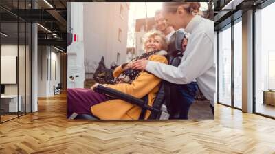 Senior woman in wheelchair being picked up by transport service Wall mural