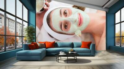 Smiling woman getting facial treatment in beauty salon Wall mural