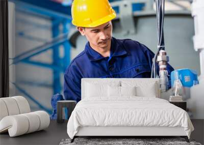 Technician in factory at machine maintenance Wall mural