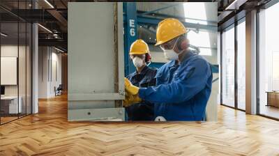 Two blue-collar workers wearing protective equipment while insulating an industrial pressure vessel Wall mural