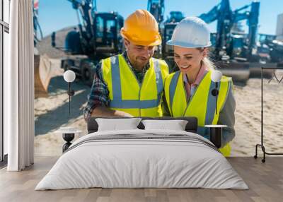 Two workers in open cast mine standing in front of heavy machinery Wall mural