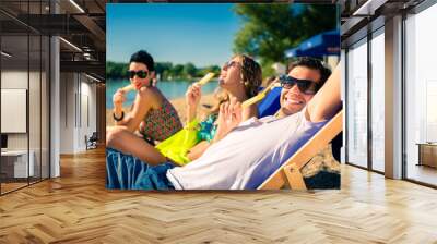 Woman and man eating ice cream on beach Wall mural