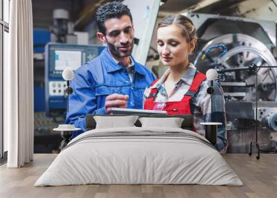 Woman and man manufacturing worker in discussion  Wall mural