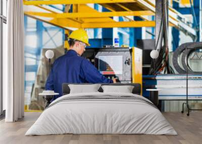 Worker in manufacturing plant at machine control panel Wall mural