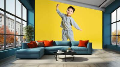 full body image of boy posing on a yellow background. Wall mural