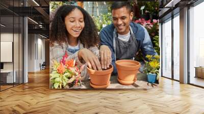 Couple, happy and gardening plants together for agriculture nutrition, nature wellness and soil sustainability in nursery. Spring garden, man and woman smile for ecology planting or green energy Wall mural