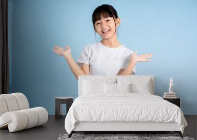 Portrait of Asian girl posing on blue background Wall mural