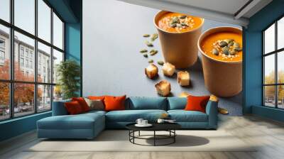 Thick vegan pumpkin cream soup with seeds and croutons in disposable cups of craft paper. Soup to go. Healthy food delivery. Space for text
 Wall mural