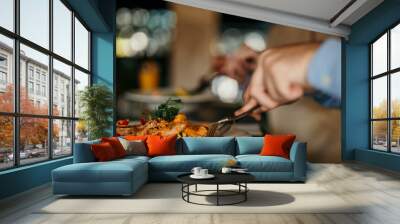 Close-up image of peoples hands cutting a dish while they having lunch at a restaurant Wall mural