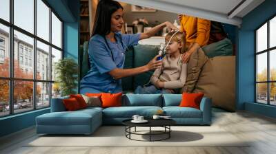 The doctor gives oxygen therapy to a young girl who is sick and has pneumonia at home. healthcare and medical concept Wall mural