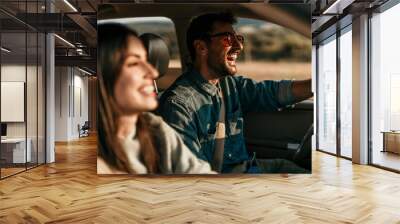 Young couple enjoying the freedom on a Car Trip over a country offroad Wall mural