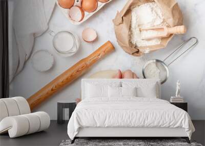 Woman preparing dough.  Flour, milk, eggs and other ingredients on a marble table. The concept of home baking. Culinary background. Selective focus, top view Wall mural