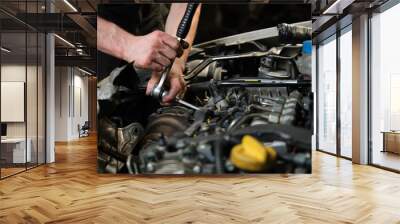 Close up of car mechanic hands doing car service and maintenance. Mechanics workshop. Wall mural