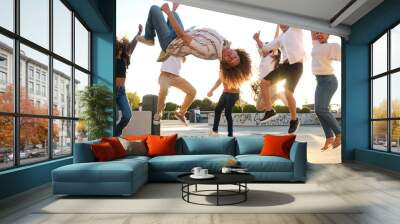 Group of young people are jumping in the air, celebrating their friendship Wall mural