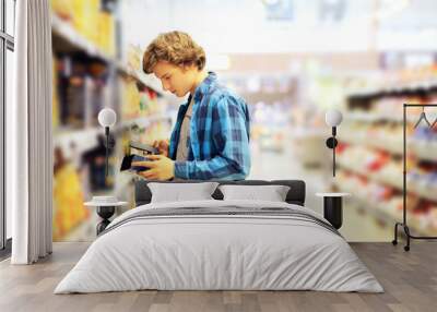 Young man in the supermarket .Young man buying foods at the market Wall mural