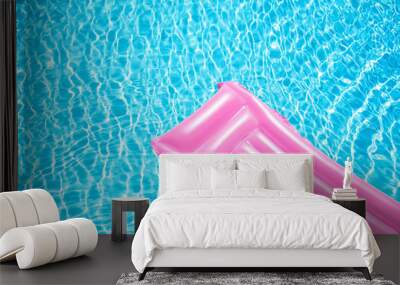 Beach summer holiday background. Inflatable air mattress on swimming pool water. Pink lilo and summertime accessories on poolside. Top view and copy space Wall mural