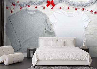 Close up white blank template t shirt, gray sweatshirt hoodie with copy space and Christmas Holiday concept. Top view mockup t-shirt, red bow on white wooden background. Happy New Year decorations Wall mural