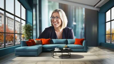 Bringing positive energy to the workplace. Shot of a happy businesswoman in a modern office. Wall mural