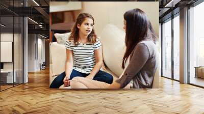 Conversation, mother with daughter talking on sofa and living room in their home. Communication or discussion, family or bonding time and female parent with child chatting on couch or lounge Wall mural