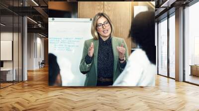 Heading up a winning project. Shot of a group of colleagues having a brainstorming session in a modern office. Wall mural