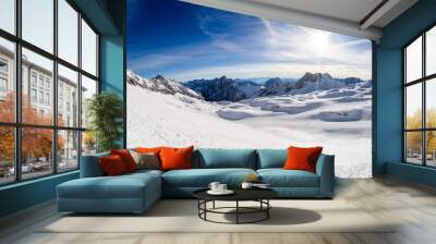 sun on ski slope and panorama of the snowy alps from the ski resort Wall mural