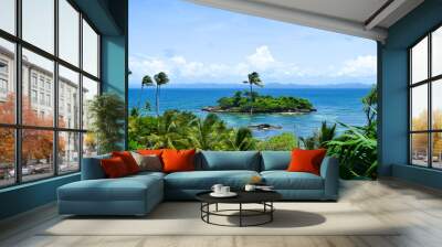 View over island in caribbean sea with many palms, blue sky, some clouds on the horizon, tropical island Wall mural