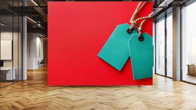 Minimalistic green sale tags on a solid red background for promotional offers Wall mural