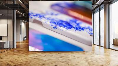 Macro shot of abstract painted mobile phone cases. Beautiful handmade drawings and personalized design for smartphones. Cases laying on table in row. Blue, white, pink, purple, red, yellow colors used Wall mural