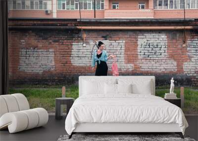 two young women with shopping bags walking in the city Wall mural