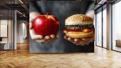 Hands holding an apple and a hamburger side by side showing healthy vs unhealthy food choice	 Wall mural