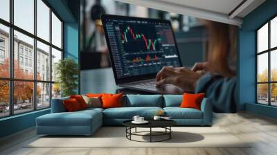 Close-up of a businesswoman typing on a laptop with financial charts on the screen Wall mural